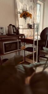 a living room with a table and a microwave at Tranquil Haven Retreat in Hamilton