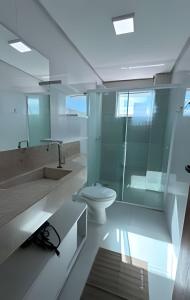 a bathroom with a toilet and a glass shower at Apto Copo Leite|3Q c|Sacada,Churrasqueira,na Aven in Piratuba +14 photos