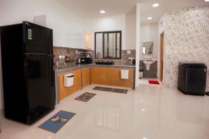 a large kitchen with a black refrigerator in a room at Central Phu Quoc Villa in Phú Quốc