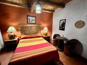 a bedroom with a bed and two tables and two lamps at Hotel Mi Pueblito Tapalpa in Tapalpa