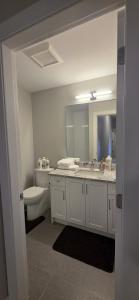ein Badezimmer mit Waschbecken, Toilette und Spiegel in der Unterkunft 2768 Celestial in Goldstream Station + 10 Fotos