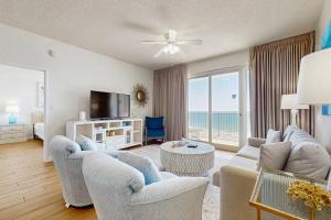 a living room with a couch and chairs and a television at TOPS'L Tides 704 in Destin