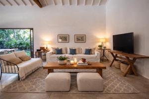 a living room with a couch and a tv at Casa Pini - Condomínio Altos de Trancoso, próxima ao Quadrado in Trancoso