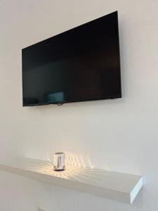 a tv on a wall with a glass on a shelf at Hotel Rincón Samaná in Las Galeras