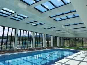 a swimming pool in a building with windows at ILLITE Hotel in Yŏngdong