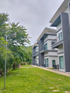 an apartment building with a green lawn in front of it at Kakse Teschor Mong Reththy Senchey in Phumĭ Svay Dângkum