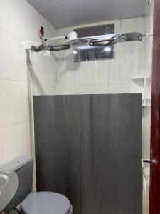 a bathroom with a shower curtain and a toilet at Doce Lar Alto Caparaó in Caparaó Velho +9 photos