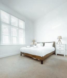 a white bedroom with a bed and a window at 7 The Cathedrals in Durham