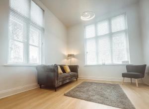 a living room with a couch and two windows at 7 The Cathedrals in Durham