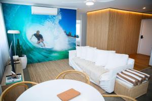 a living room with a large painting of a surfer on a wave at El Parche Bilinga Beachside in Gold Coast