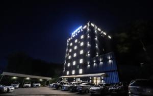 a lit up building with cars parked in a parking lot at Hotel Avenue in Tansa-gol