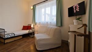a small room with a white chair and a window at Apartmány V Podzámčí in Mělník