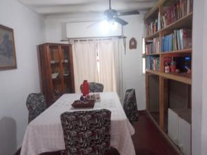 a dining room with a table and chairs and bookshelves at El Jacaranda in Carmen de Patagones