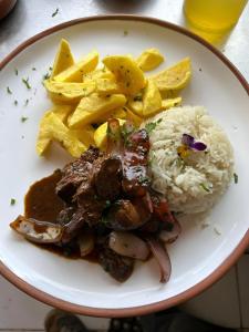 a plate of food with meat and rice and chips at Hanging Nest Salkantay in Colcapampa