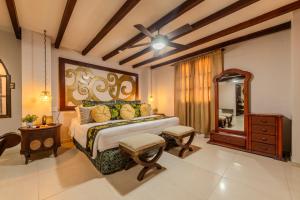 a bedroom with a king sized bed and a dresser at Hotel Dorado Plaza Boutique Calle del Arsenal in Cartagena de Indias +108 photos