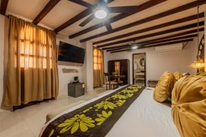 a room with a bed and a tv and a couch at Hotel Dorado Plaza Boutique Calle del Arsenal in Cartagena de Indias