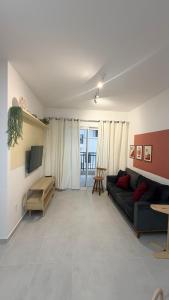 a living room with a couch and a tv at Mar e Natureza 2 quartos 6 Pessoas Lazer in Bertioga
