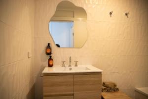 a bathroom with a sink and a mirror at El Parche Bilinga Beachside in Gold Coast +60 photos