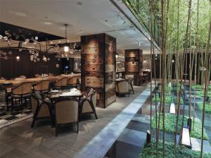 a restaurant with tables and chairs and trees at Dhawa Yura Kyoto in Kyoto