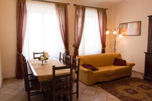 a dining room with a table and a yellow couch at Note in Val d'Orcia in San Quirico dʼOrcia