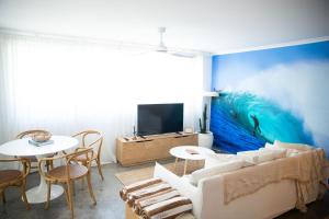 a living room with a large painting on the wall at El Parche Bilinga Beachside in Gold Coast