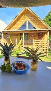 a table with a bowl of fruit and two plants at Pousada PortoBello Praia do Rosa in Imbituba +17 photos