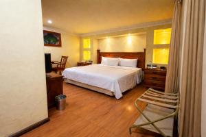 a bedroom with a bed and a chair in it at Hotel Ruinas Resort in Huehuetenango