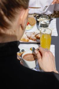 a woman sitting at a table with a cup of coffee at Dama Luxury Suites Pompei in Pompei +78 photos