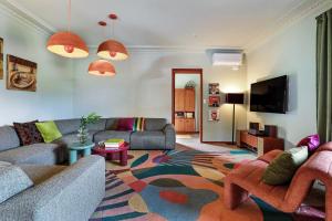 a living room with two couches and a tv at Thirroul Beach Apartments in Thirroul