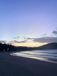 a view of a beach at sunset with the ocean at Emil's Beach Cottage in El Nido +3 photos