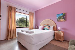 a bedroom with a large bed with purple walls at Thirroul Beach Apartments in Thirroul