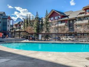 a swimming pool in front of some houses at One Bedroom Mountain View Condo - Lodges at Canmore in Canmore