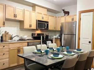 a kitchen with a table with chairs and a refrigerator at One Bedroom Mountain View Condo - Lodges at Canmore in Canmore
