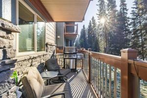 a balcony with chairs and a grill on a house at One Bedroom Mountain View Condo - Lodges at Canmore in Canmore