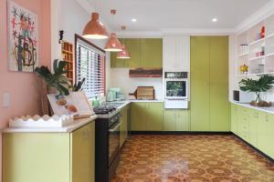 a kitchen with green cabinets and a stove top oven at Thirroul Beach Apartments in Thirroul +24 photos