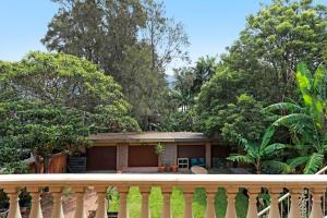 a house with a fence and trees at Thirroul Beach Apartments in Thirroul