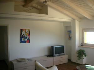 a living room with a tv on a white wall at Villa Susina in Toscolano Maderno