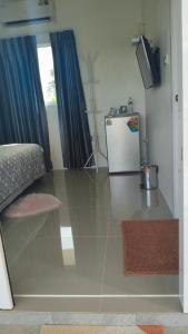 a living room with a tiled floor with a refrigerator at Ban Pai Khlung Resort in Chanthaburi