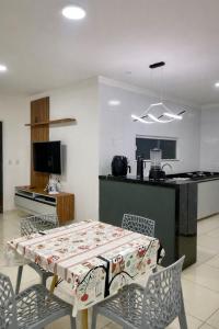 a kitchen with a table and chairs and a kitchen with a table and a table at Casa 186 in Juazeiro do Norte