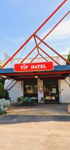 a hip motel with chairs and tables in front of it at TIP HOTEL CAMBRAI ex HOTEL F1 in Cambrai