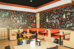 a restaurant with tables and a wall covered in graffiti at Hotel Ruinas Resort in Huehuetenango