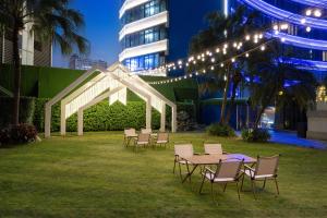 a group of tables and chairs in a yard with lights at Ocean Hotel Guangzhou in Guangzhou