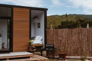 a small cabin with a couch and a table at Omoho Stream X by Tiny Away in Kennedys Bay