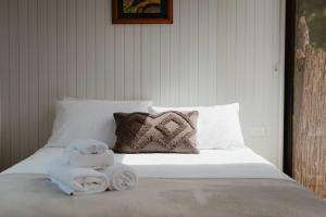 a bed with towels and a stuffed animal on it at Omoho Stream X by Tiny Away in Kennedys Bay