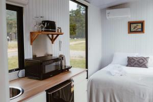 a small room with a bed and a tv at Omoho Stream X by Tiny Away in Kennedys Bay