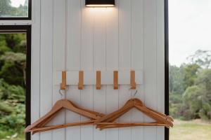 a white house with a light on the wall at Omoho Stream X by Tiny Away in Kennedys Bay +35 photos