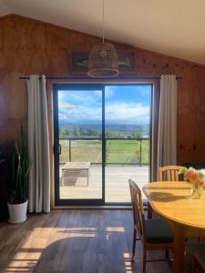 a dining room with a table and a large window at Flax Ridge in Hokitika Airport +16 photos