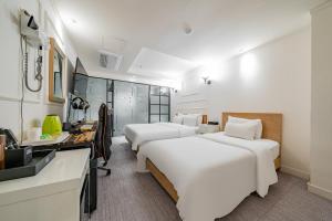 a hotel room with two beds and a sink at Hotel Avenue in Tansa-gol