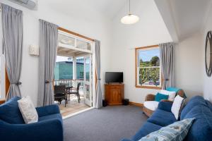 a living room with a blue couch and a tv at City Apartment South Street in Nelson +17 photos
