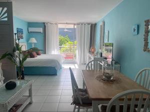 a room with a dining table and a bedroom with a bed at Sunset View & Ocean Breeze in Cul de Sac +11 photos